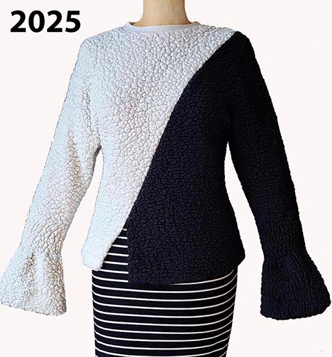 Iz črnega in belega puloverja (tekstilno krzno s strukturo ovčke) se z diagonalnim rezom obeh, rodi sofisticirana harmonija barvnih nasprotij